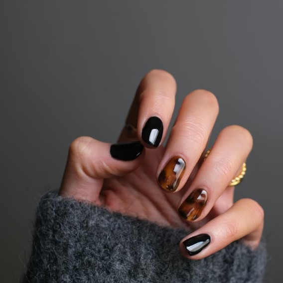 Close-up of hand-painted floral nail art on short almond nails